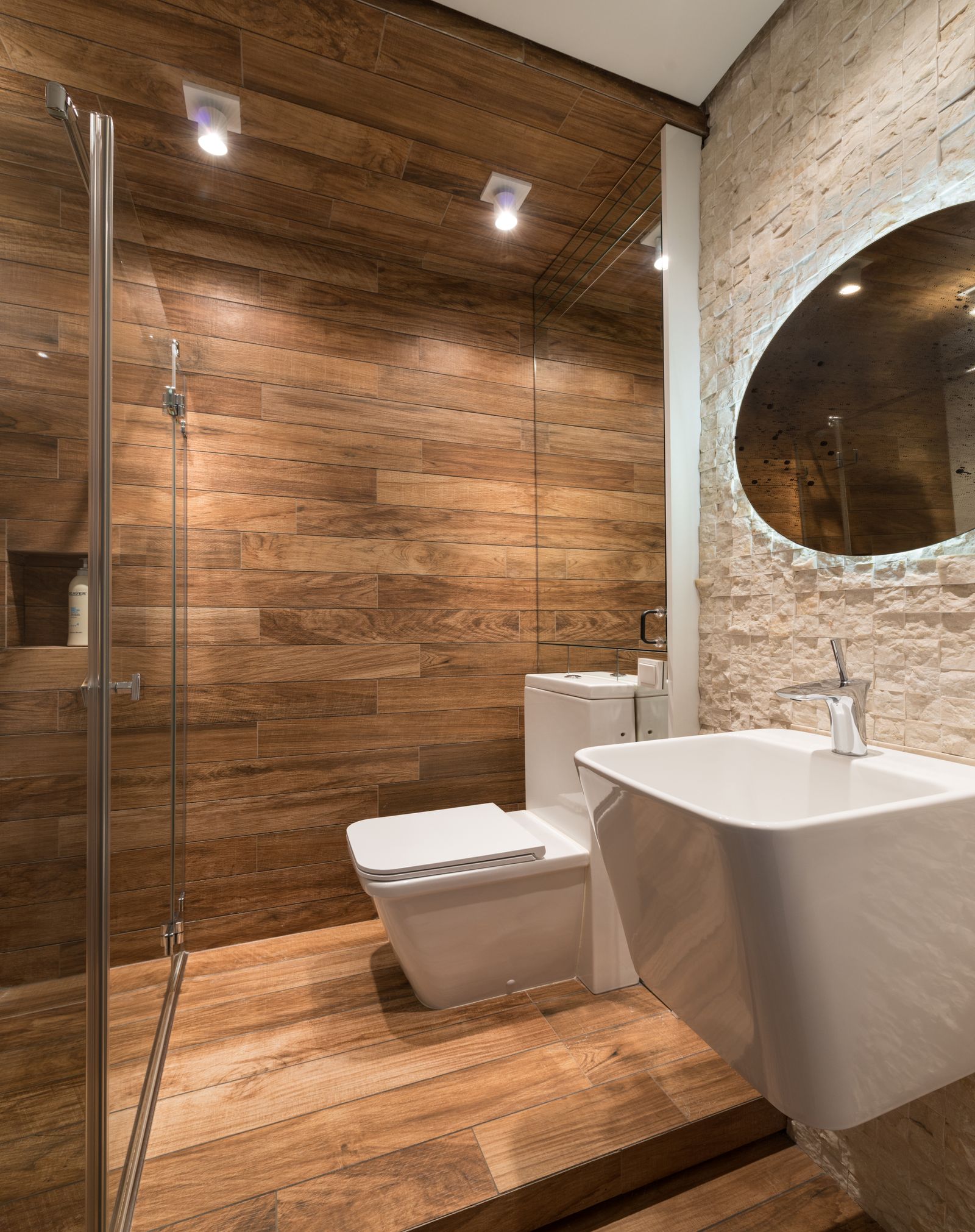 Salle de bains chaleureuse en lames de bois et mur de pierre naturelle